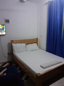 a bed in a room with a blue curtain at Asante Studio in Mtwapa