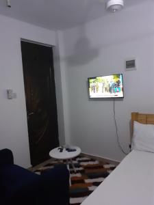 a room with a bed and a table and a window at Asante Studio in Mtwapa