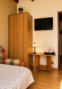 a bedroom with a bed and a desk with a television at Leśne Zacisze in Iława