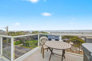 a table and chair on a balcony with a view of the ocean at Harbor SeaShell in Lincoln City