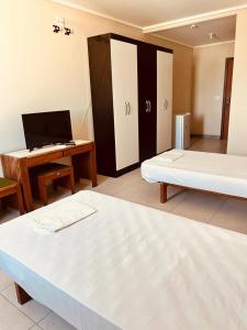 a room with two beds and a desk and a laptop at Hotel Mata da Praia in Vitória +8 photos