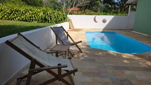 a pair of chairs sitting next to a swimming pool at Reserva Cambucá - Afeto, Pessoas e Sabores in Itirapina