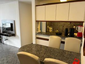 a kitchen with a table and chairs and a counter at Atlantico Flat in Fortaleza