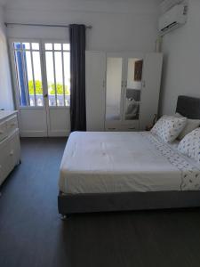 a bedroom with a bed and a large window at Beau appt vue mer à gammarth in Gammarth