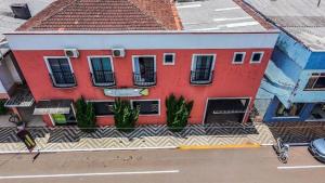 a red building on the side of a street at Hotel e restaurante Camicia in Maximiliano de Almeida