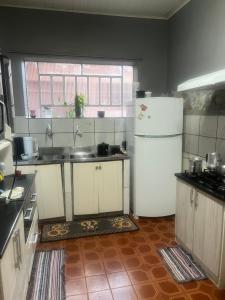 a kitchen with a white refrigerator and a window at Hotel e restaurante Camicia in Maximiliano de Almeida