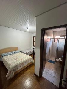 a bedroom with a bed and a shower in it at Hotel e restaurante Camicia in Maximiliano de Almeida