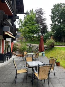 a patio with tables and chairs and an umbrella at Kronenlodge in Seefeld in Tirol