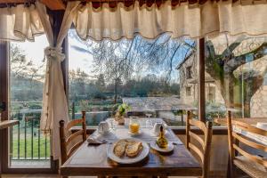 una mesa con comida delante de una ventana en Los Montejos & Spa, en Valverde del Fresno