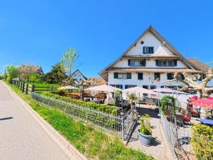 a building with tables and umbrellas in front of it at Gemütliche und ruhige Wohnung in Rifferswil