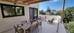 a patio with a wooden table and chairs on a balcony at TAO House in Ferma