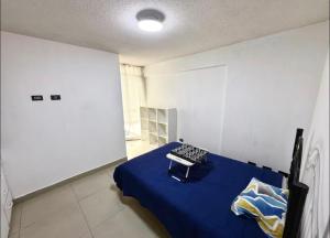 a bedroom with a blue bed in a white room at Studio Brasil 861 in Lima
