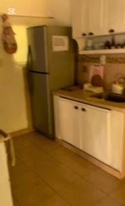 a kitchen with a green refrigerator and white cabinets at Casa tranquila Paso de la Patria in Paso de la Patria