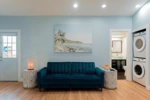 a living room with a blue couch and a washing machine at Starfish Beach House in Clearwater Beach