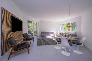 a living room with a couch and a table and chairs at Coloratura Frontlake Lugano with Terrace - Happy Rentals in Paradiso