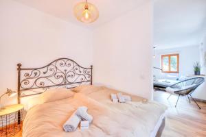 a bedroom with a bed with two towels on it at Casa Elvezia in Val Colla | Terrace + BBQ & Fireplace - Happy Rentals in Piandera