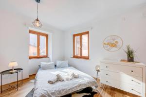 a white bedroom with a bed and a dresser at Casa Elvezia in Val Colla | Terrace + BBQ & Fireplace - Happy Rentals in Piandera