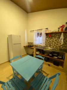 a kitchen with a table and chairs and a refrigerator at Ypê Hospedagem in Sao Jorge
