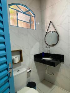 a bathroom with a sink and a mirror and a toilet at Ypê Hospedagem in Sao Jorge +17 photos