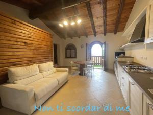 a living room with a white couch and a kitchen at B&B Bernacco in Vallio Terme