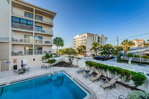 a swimming pool with chairs and a building at Hidden Beach Retreat in Clearwater Beach +30 photos