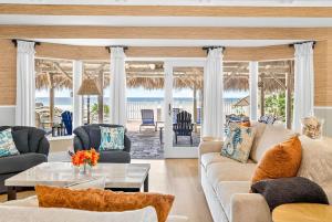 a living room with a couch and chairs and the ocean at Gulf Front Dreams in Clearwater Beach