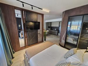a bedroom with a bed and a tv in a room at Superior Jacuzzi Apartment Sea Side Terrace in Eforie Nord +24 photos