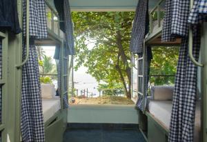 a room with a window with a view of a tree at The Beachside Hostel in Anjuna