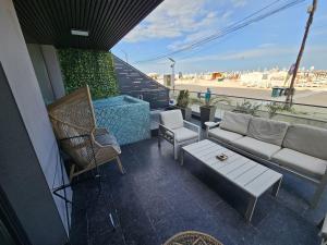 a living room with a couch and chairs on a balcony at Superior Jacuzzi Apartment Sea Side Terrace in Eforie Nord