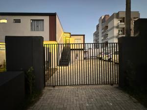 a black gate with a brick walkway next to some buildings at Studios Botânico in Curitiba