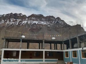 a large building with a mountain in the background at Ochre Spiti in Lara
