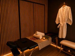 a room with a table and a robe hanging up at Evasion Terracotta - Jacuzzi privatif in Saint-Gaudens