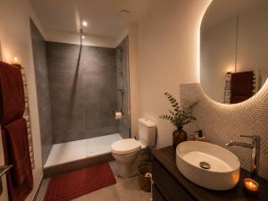 a bathroom with a sink and a toilet and a shower at Evasion Terracotta - Jacuzzi privatif in Saint-Gaudens