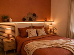 a bedroom with a bed with two lamps and candles at Evasion Terracotta - Jacuzzi privatif in Saint-Gaudens +5 photos