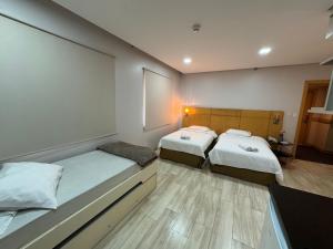 a room with two beds and a window at Hotel Flat Guarulhos 5 in Guarulhos +16 photos