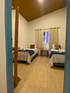 a room with two beds and a window at Ypê Hospedagem in Sao Jorge