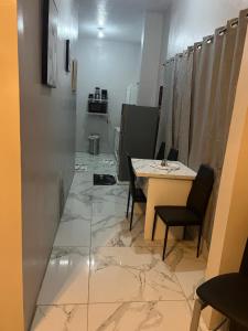 a room with a table and chairs on a marble floor at Op paradise living in Kingston