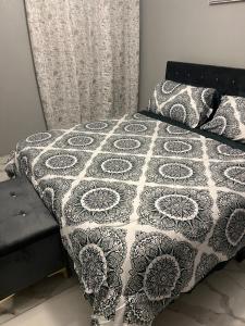 a bed with a black and white quilt on it at Op paradise living in Kingston