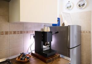 a kitchen with a coffee maker next to a refrigerator at La Stellina Capri in Capri