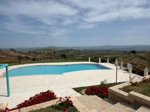 a swimming pool with a view of the hills at B&B Villa Brikinnia in Lentini