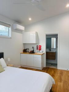 a bedroom with a white bed and a kitchen at Sapphire Beach Studio in Sapphire Beach