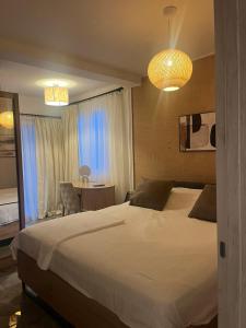 a bedroom with a bed and a chair and a window at Apartmani Vukotić in Budva +29 photos