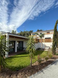 a house with a palm tree in front of it at L'Annexe de la Subérine in Vivès