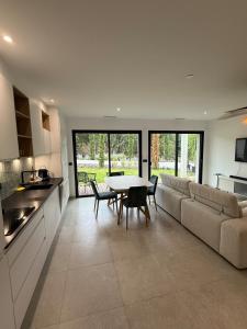a kitchen and living room with a table and a couch at L'Annexe de la Subérine in Vivès