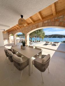 a table and chairs on a patio with a view of the water at Villa Noma in Lovište