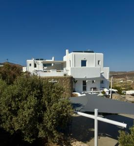 a white house on top of a hill at Villa Greystone & Sky Mykonos in Tourlos