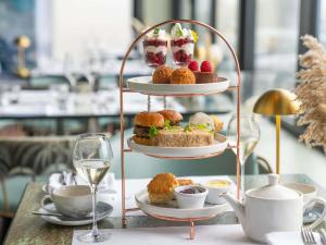 a three tiered dessertatter with pastries on a table at Mercure Brighton Seafront Hotel in Brighton & Hove