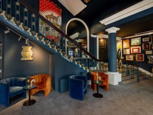 a lobby with stairs and blue chairs and tables at Mercure Brighton Seafront Hotel in Brighton & Hove +137 photos
