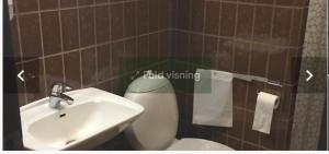 ein Badezimmer mit Waschbecken und Toilette in der Unterkunft BudgetBogense in Bogense