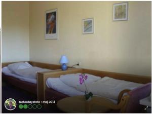 ein Schlafzimmer mit zwei Betten und einem Tisch mit Lampe in der Unterkunft BudgetBogense in Bogense